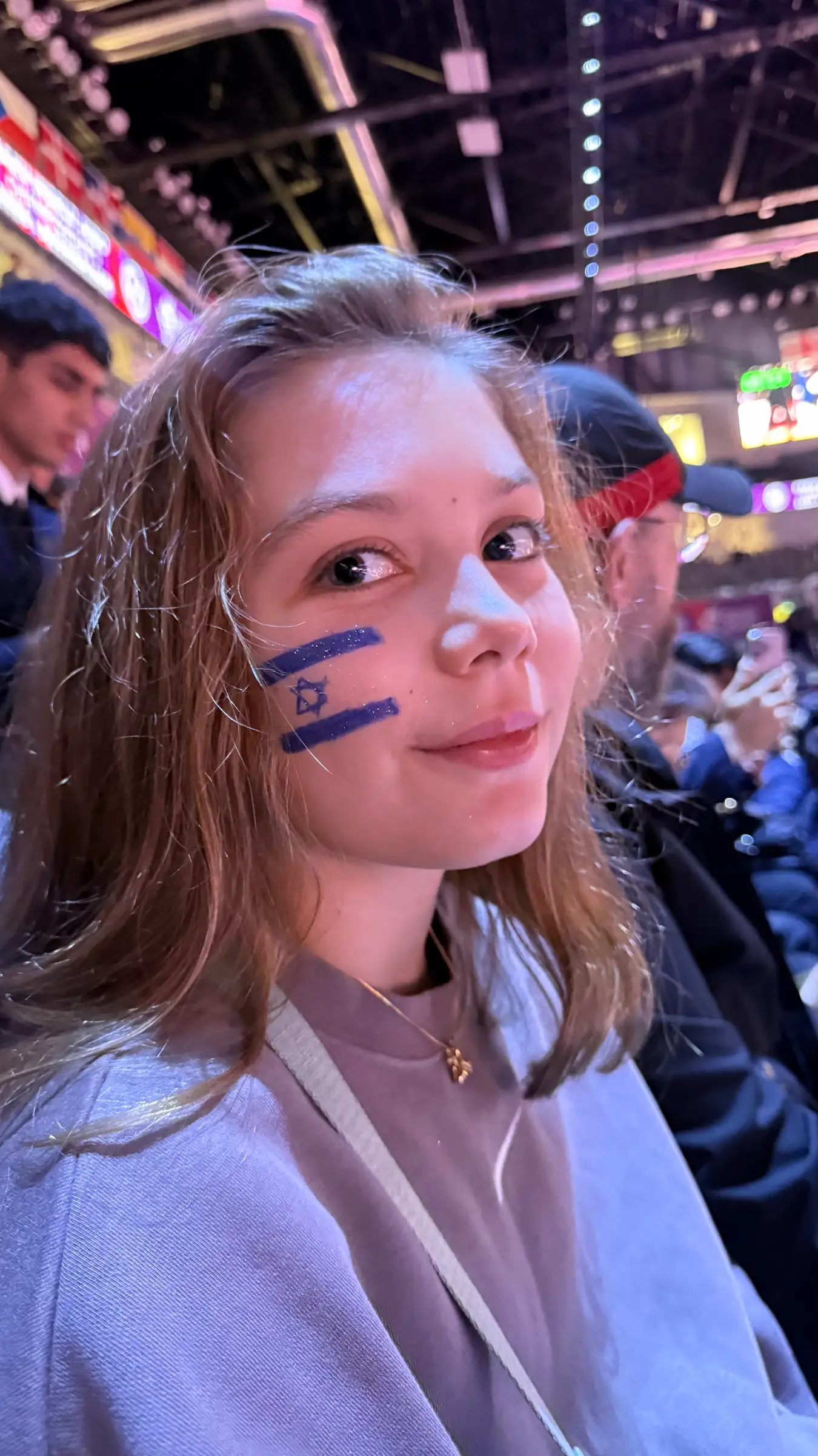 Melissa with an Israeli flag painted on her cheek, in a competition hall
