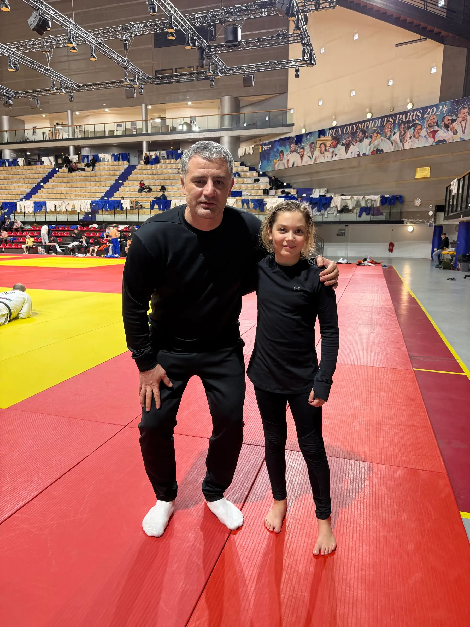 Melissa and a man in black clothes on the hall’s mat