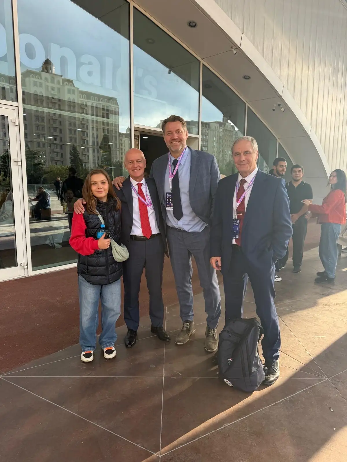 Melissa with three men in suits outside the hall