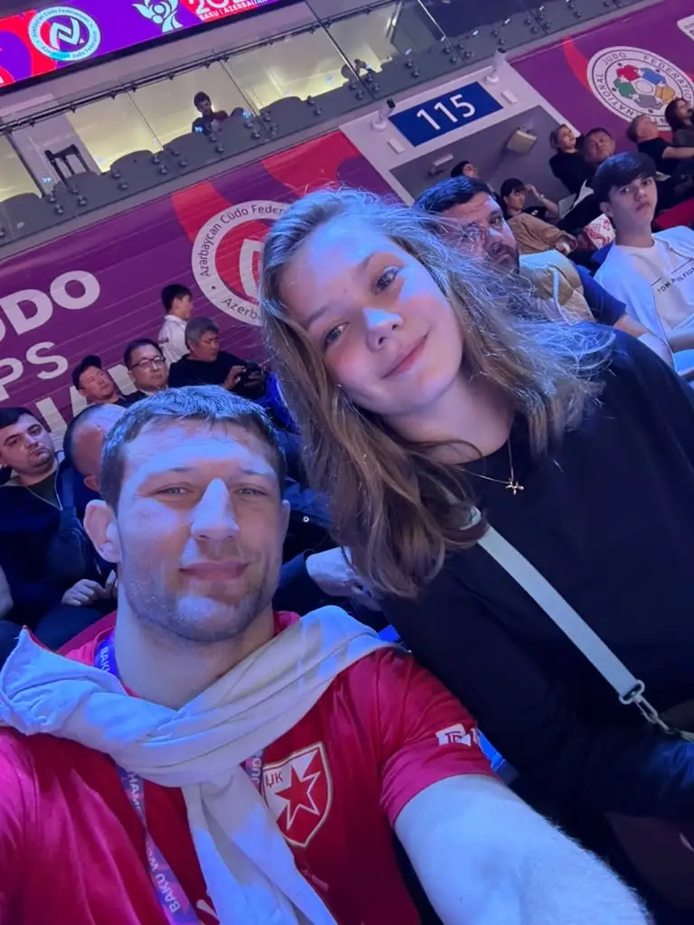 Melissa and a man in a selfie in the stands, with other people behind them