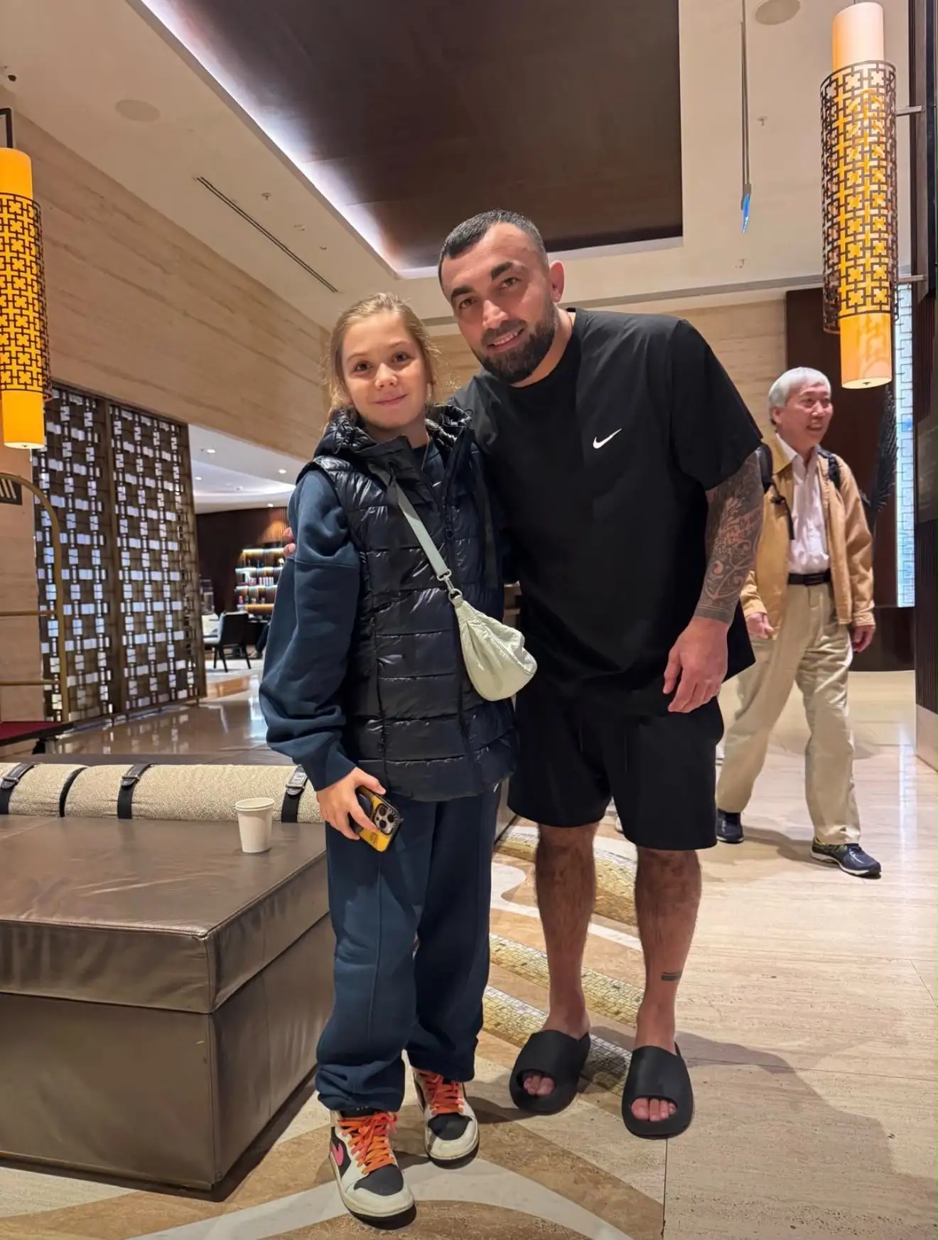 Melissa and a man in a group photo in a lobby