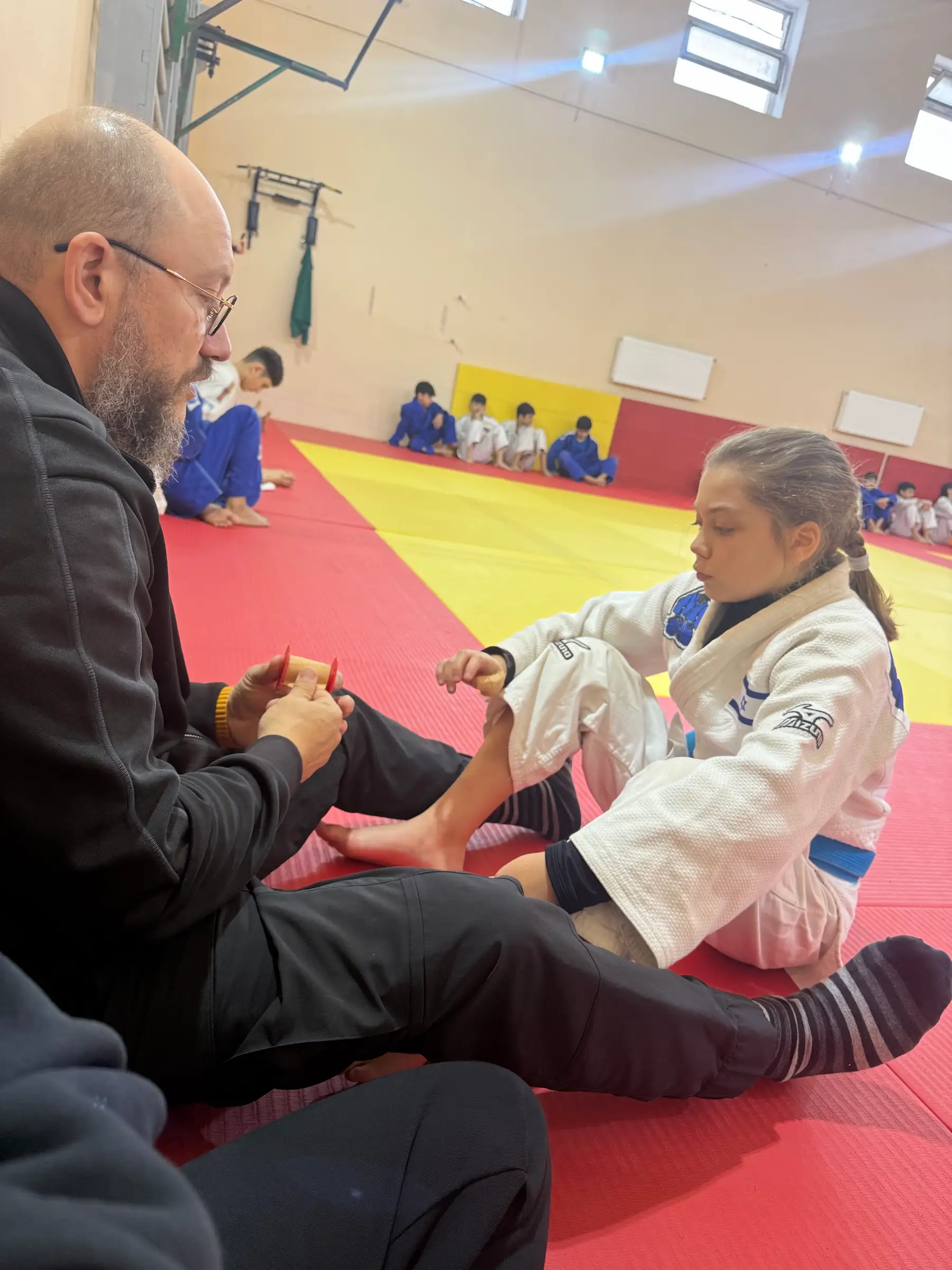 Melissa’s father wrapping her wrist with protective tape at training