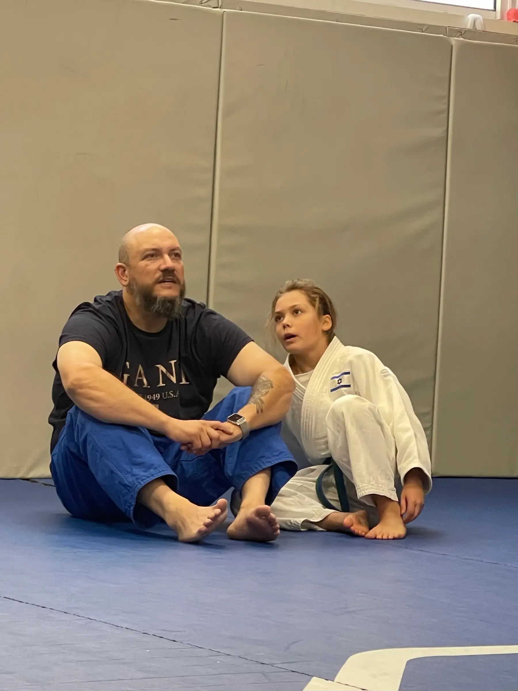 Melissa and her father sitting together on the mat, talking