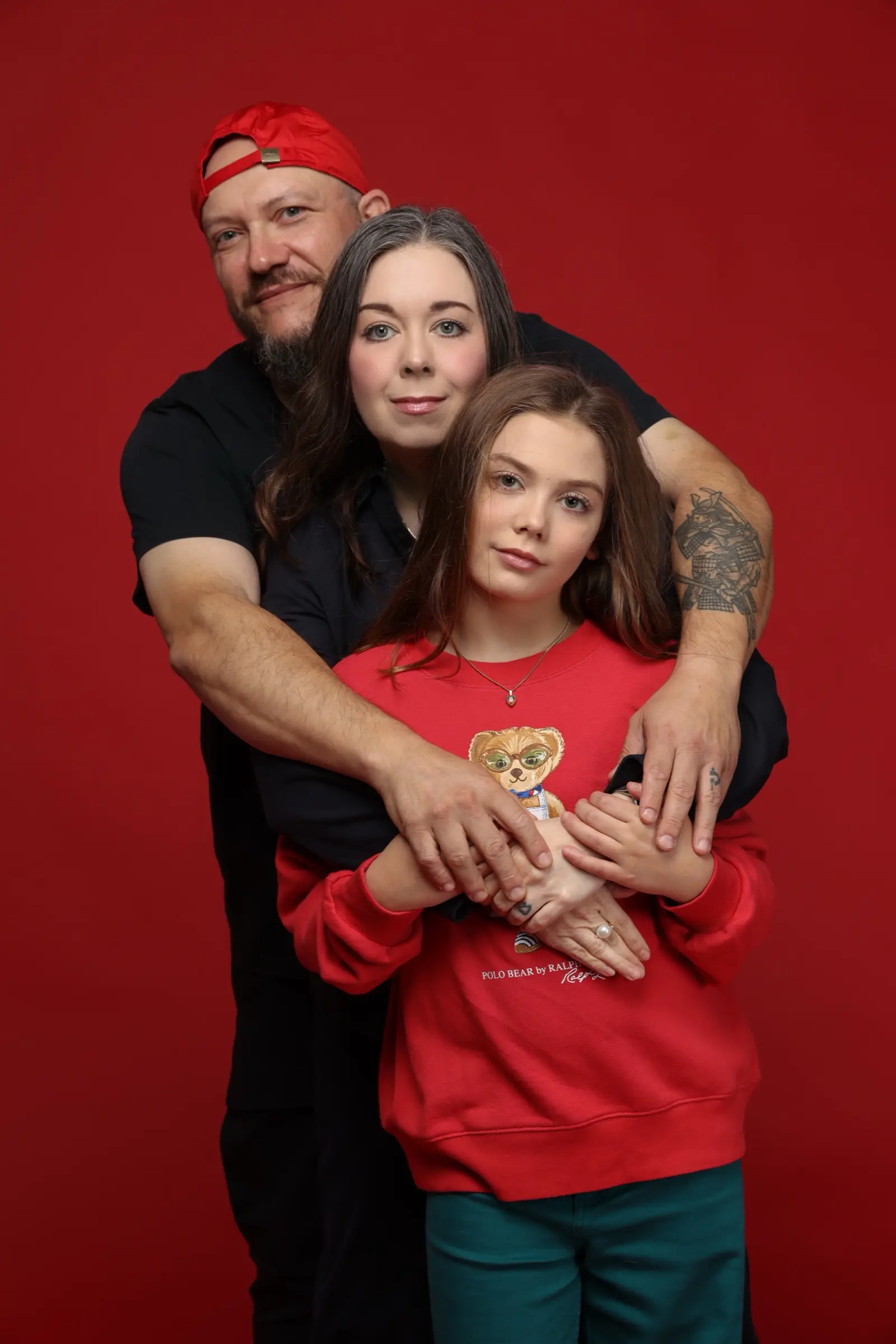 Melissa in a red shirt among her family, a family portrait in a studio