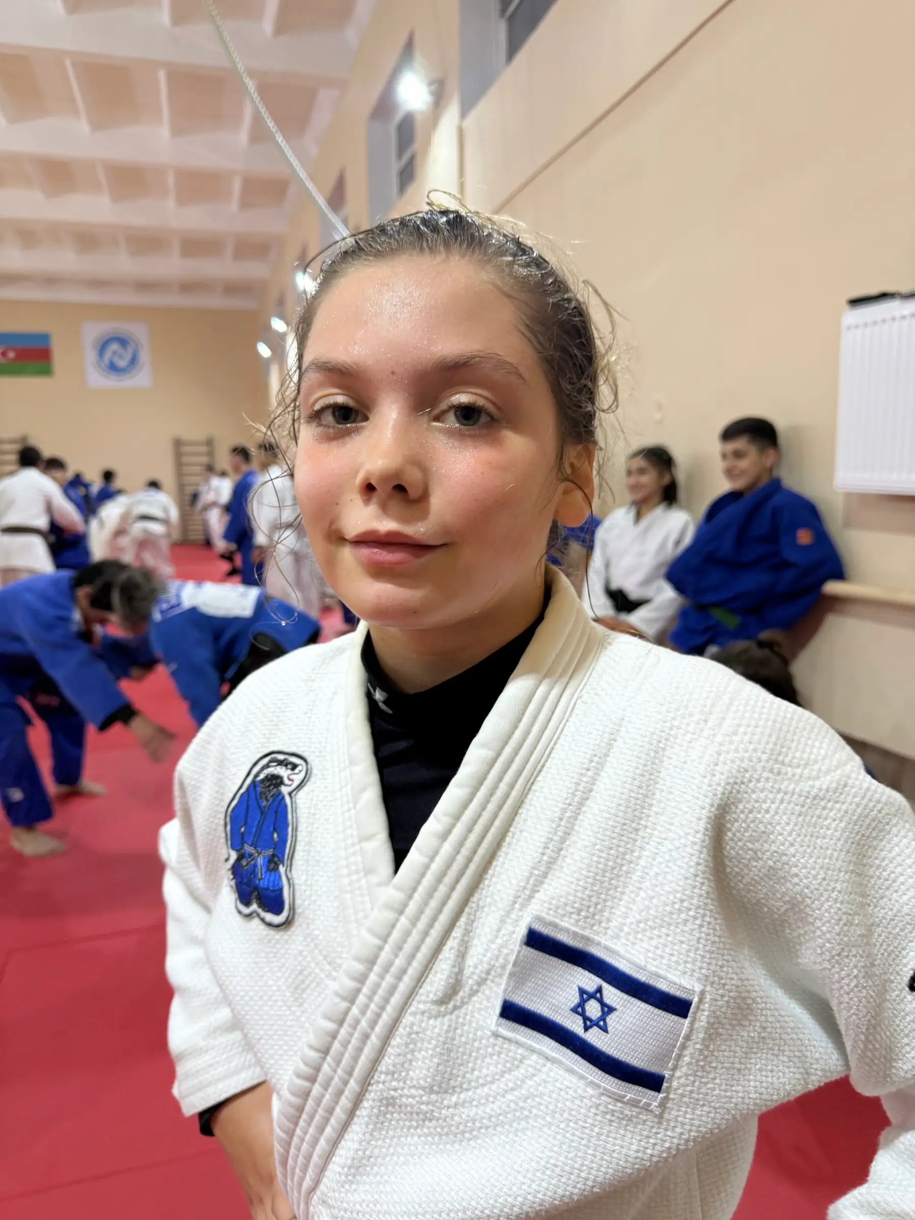 Melissa in a judo suit with the Israeli flag on the lapel, a calm and focused look